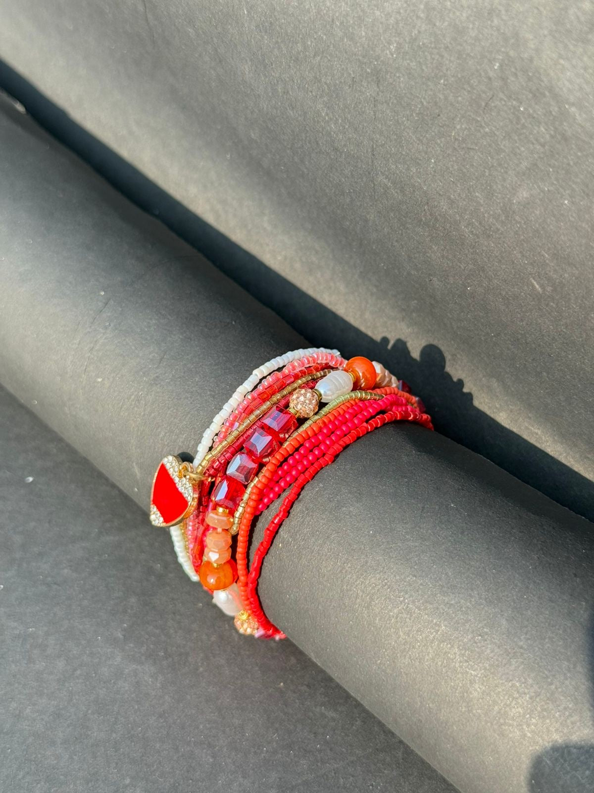 Red bracelet stack with a heart charm